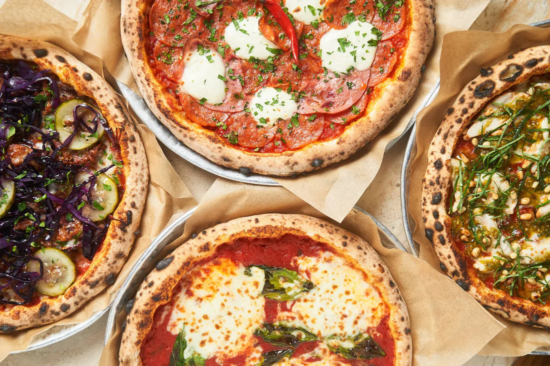 Overhead view of four fresh cooked pizzas